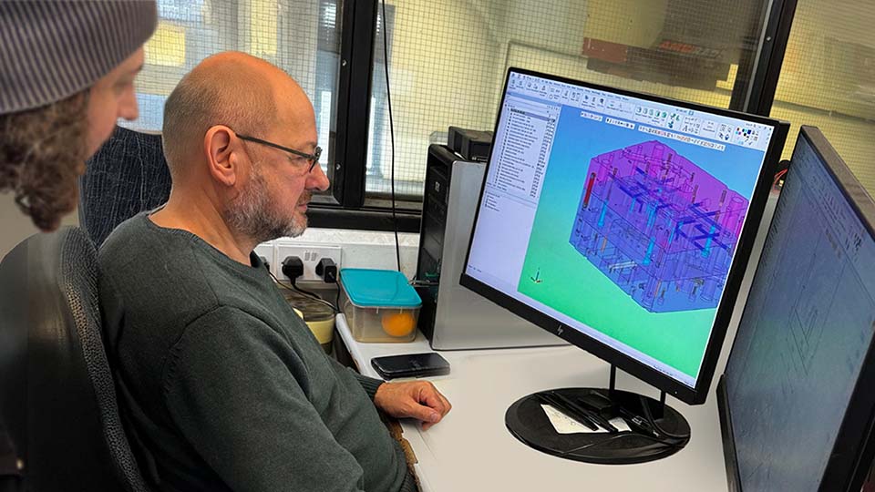 Designers Jack Bunting (standing) and Richard Capener investigate a mold design.