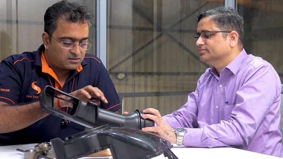 S&S Tooling Owner Santoshkumar Patil (left) shows molded automotive part to Cimatron Director Amol Mane.