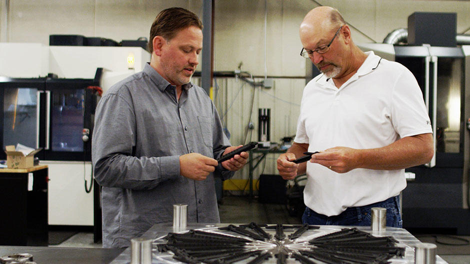 플라스틱 사출 성형에서 Cimatron을 사용해 설계 및 제조된 최종 부품을 검사하고 있는 사장 겸 CEO인 Ted Stender와 수석 금형 설계자 Dave VanDeLaare